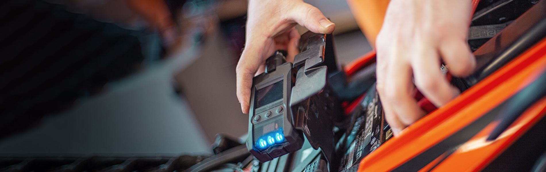 A technician connecting a diagnostic scanner to a motorcycle